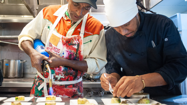 Chef marcus samuelsson plating food with blow torch