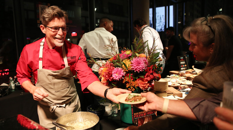 Chef Bayless handing over food