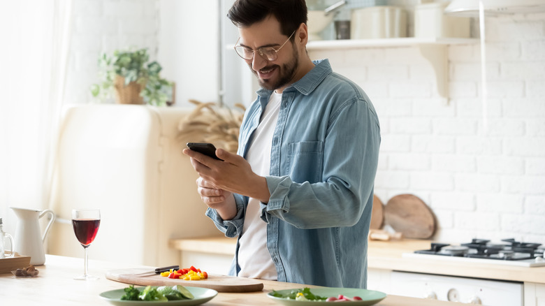 A home cook looking at a phone