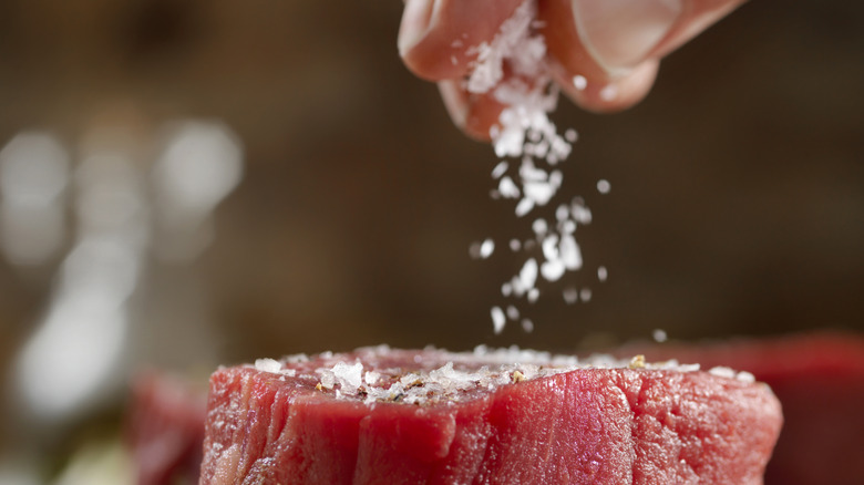 seasoning raw filet with salt