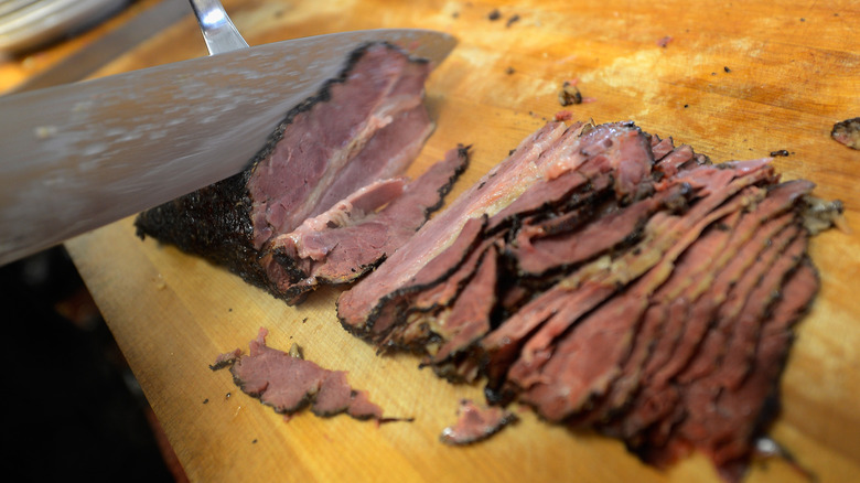 Knife slicing pastrami