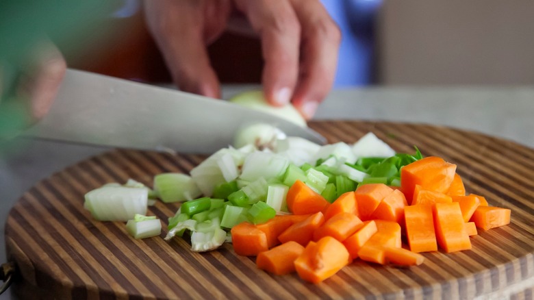 person chopping mirepoix