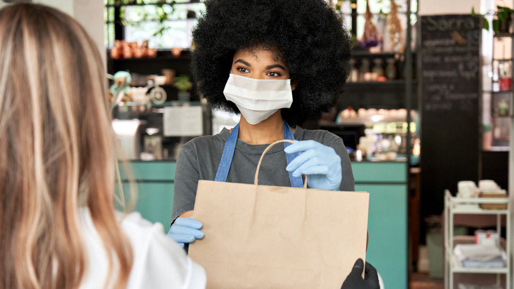 Employee handing a bag to a shopper