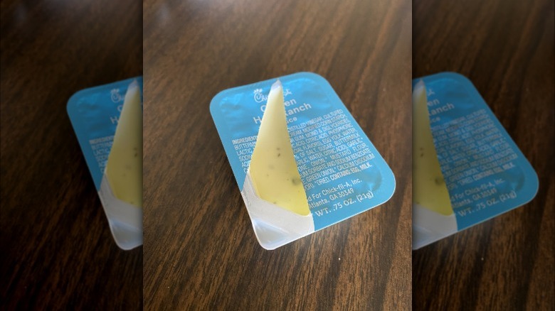 Chick-fil-A ranch package with plastic covering torn across middle