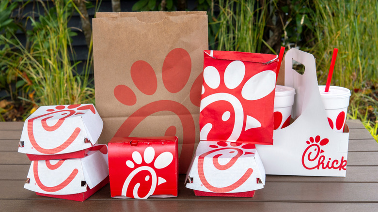 Chick-fil-A containers, bags, and cups on table