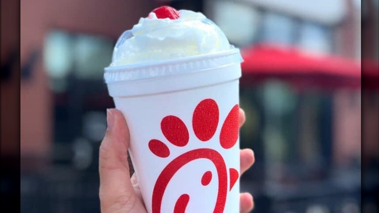 A person holding a Chick-fil-A milkshake