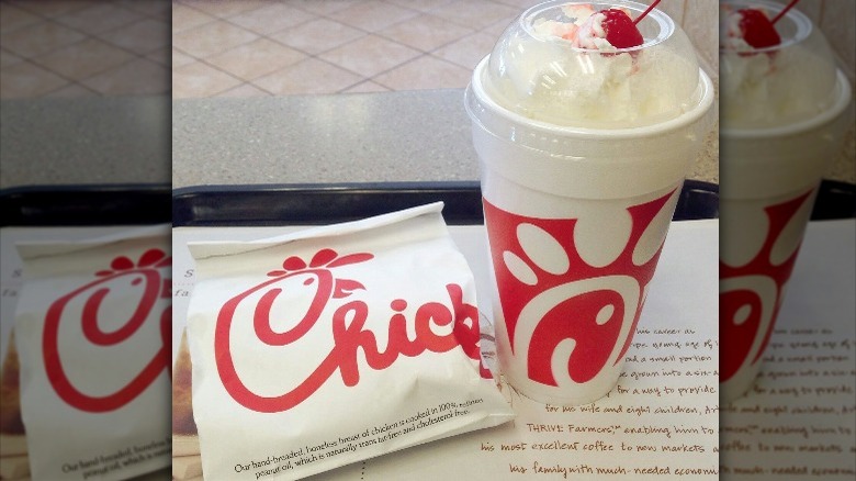 A Chick-fil-A milkshake and chicken sandwich on a tray.