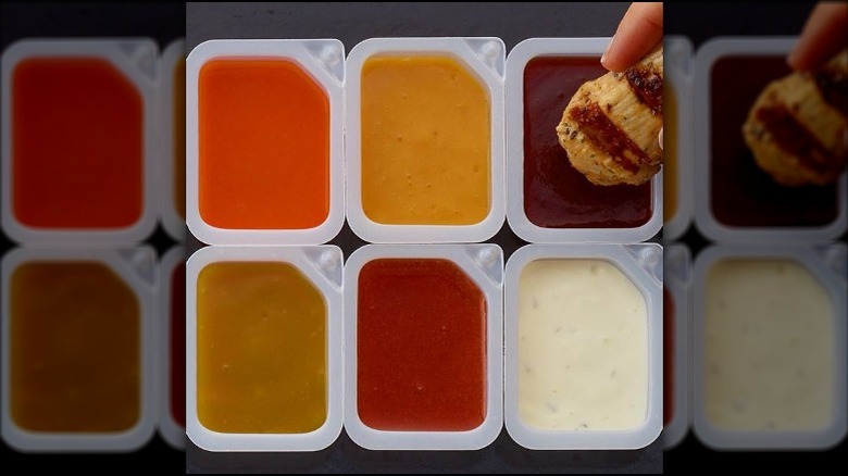 Hand dips chicken in Chick-fil-A sauces