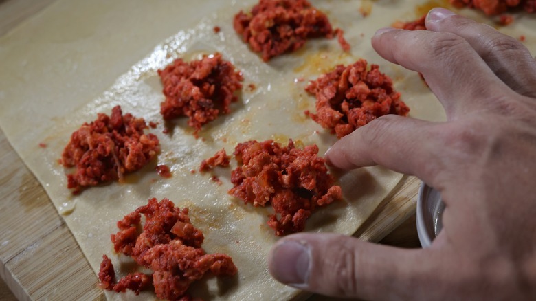 finger wetting edges of ravioli dough