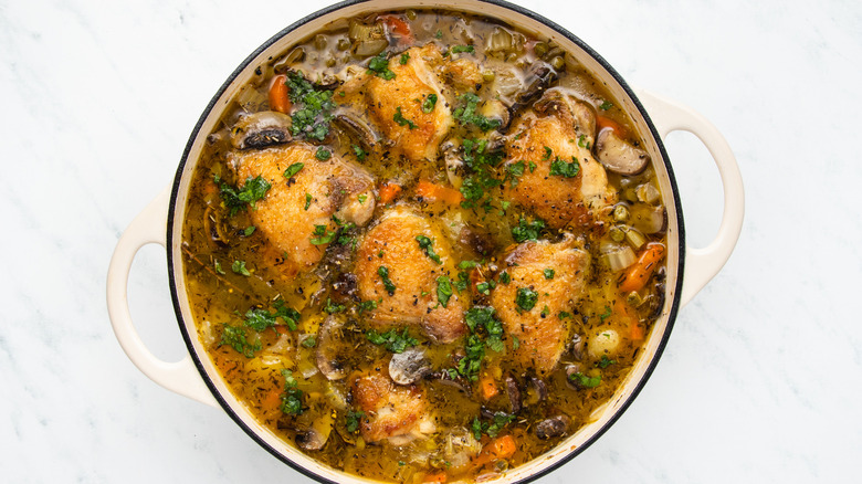 Chicken and vegetable casserole in pot with parsley