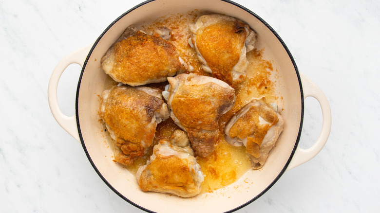 Chicken thighs browning in casserole pot