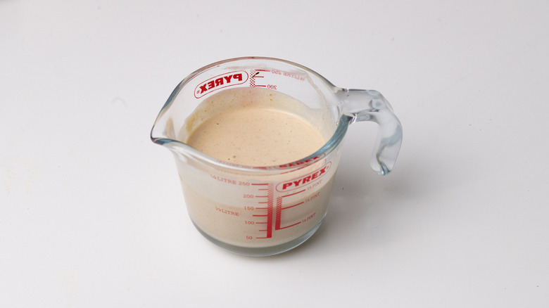 tahini dressing in measuring cup