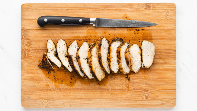 sliced chicken breast on cutting board