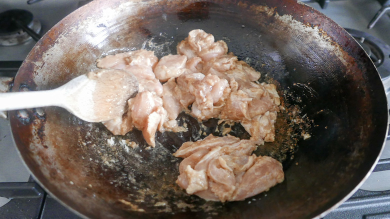 raw chicken in hot wok 