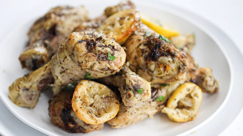 Chicken legs and lemon slices in dish