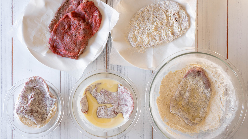 steaks in the process of breading