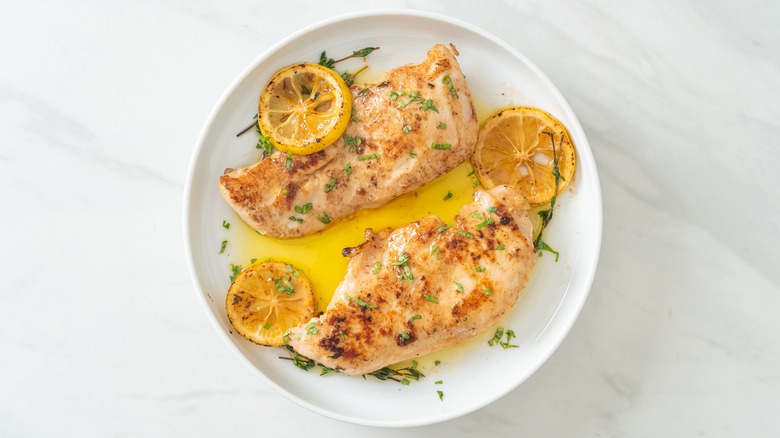 Chicken breasts on white plate with lemon slices