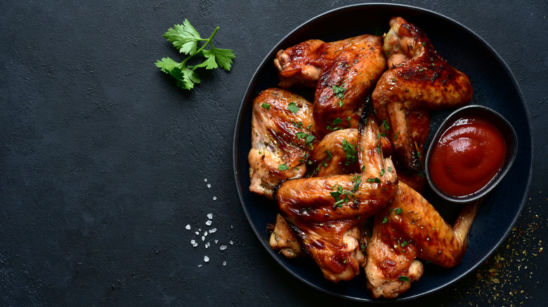 Grilled chicken legs on black plate