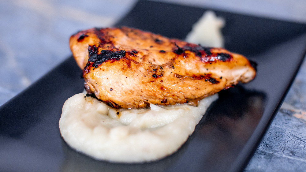 marinated and cooked chicken on a black plate