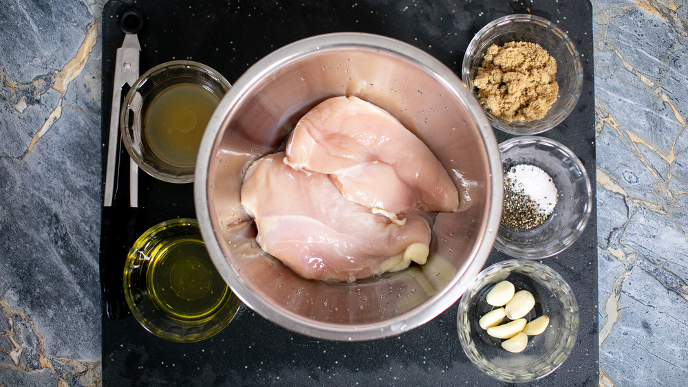 ingredients for chicken marinade in bowls on a black cutting board