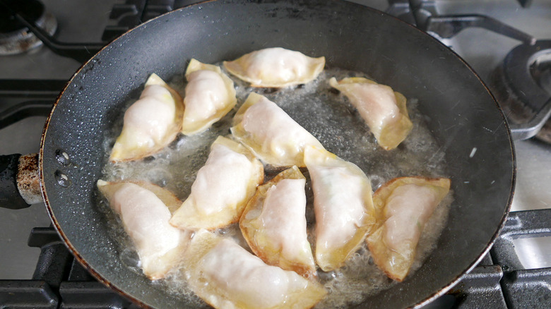 Pot stickers frying in a pan