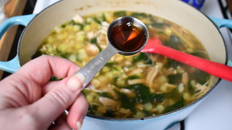 pouring fish sauce into soup