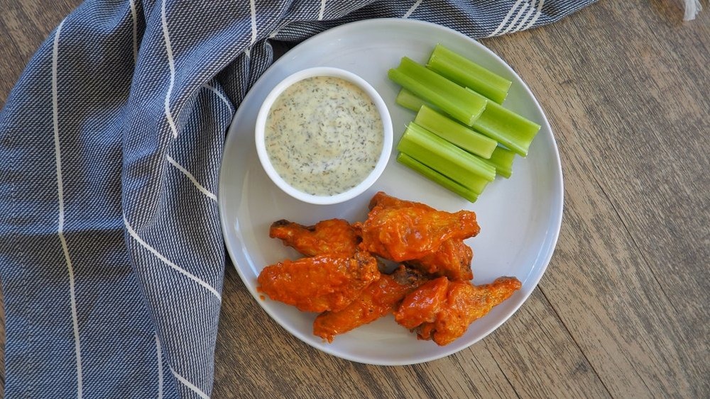 Buffalo wild wings on a plate with celery and dip