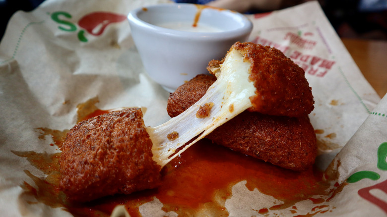 cheese pull of mozzarella stick on plate