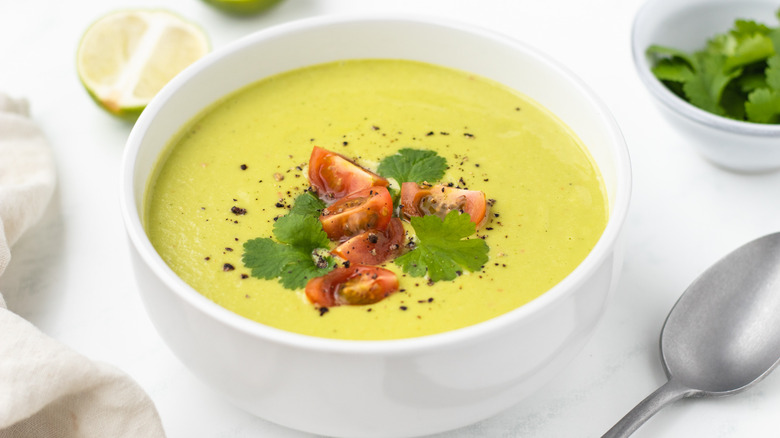 bowl of avocado soup with toppings