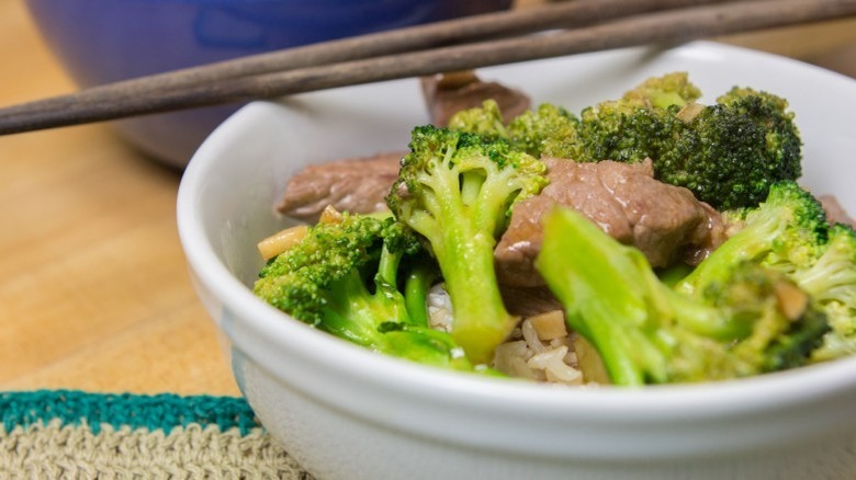 Beef And Broccoli Stir Fry in white bowl with chopsticks