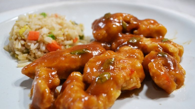 copycat panda express orange chicken on white plate with fried rice