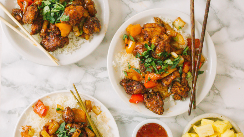 Sweet And Sour Chicken on white plates with chopsticks