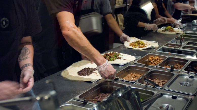 Chipotle workers preparing menu items