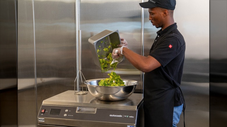 Chipotle employee prepping avocado