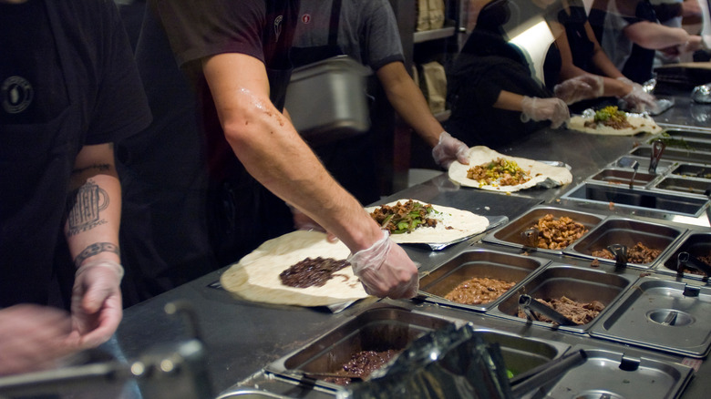 Chipotle burritos being prepared