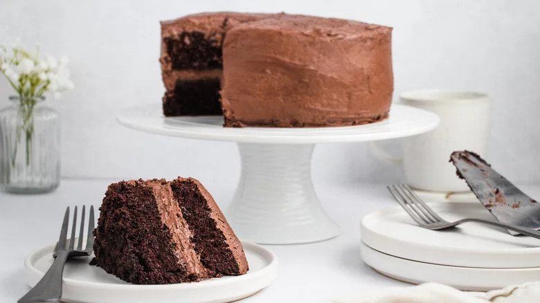 Chocolate cake on stand with slice