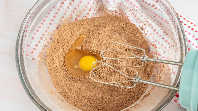 mixing egg into cupcake ingredients