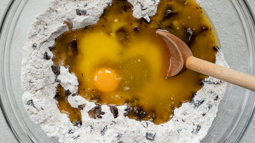 combining wet and dry chocolate chip cookie ingredients