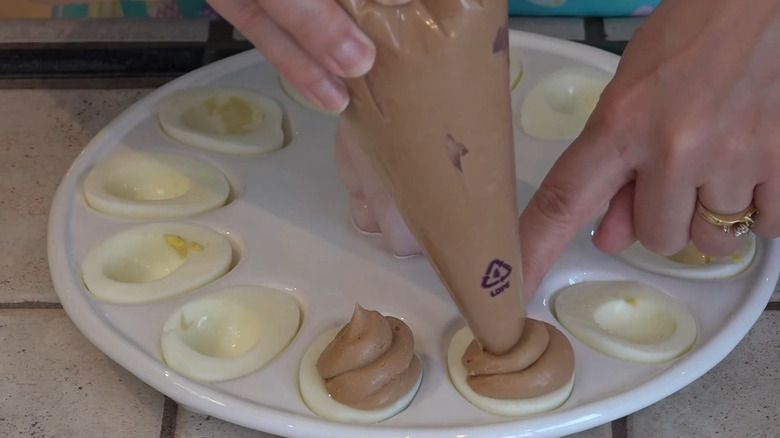 piping chocolate into egg whites for deviled eggs