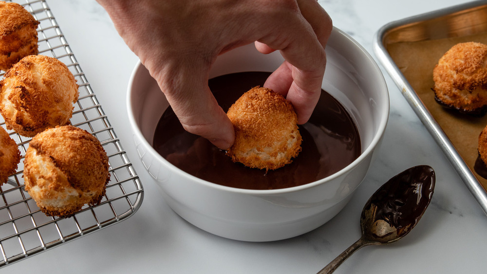 Dipping macaroons in chocolate