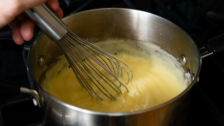 whisking mixture in saucepan