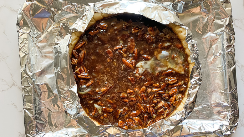 Pie with crust covered in tin foil