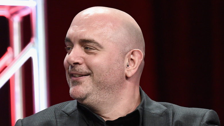 Chris Santos smiling while sitting on stage at an event.