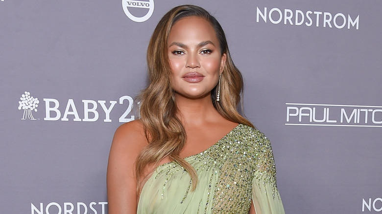 Chrissy Teigen smiles with hair down