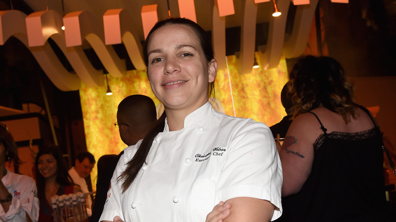 Christina Wilson smiling and crossing arms in chef attire