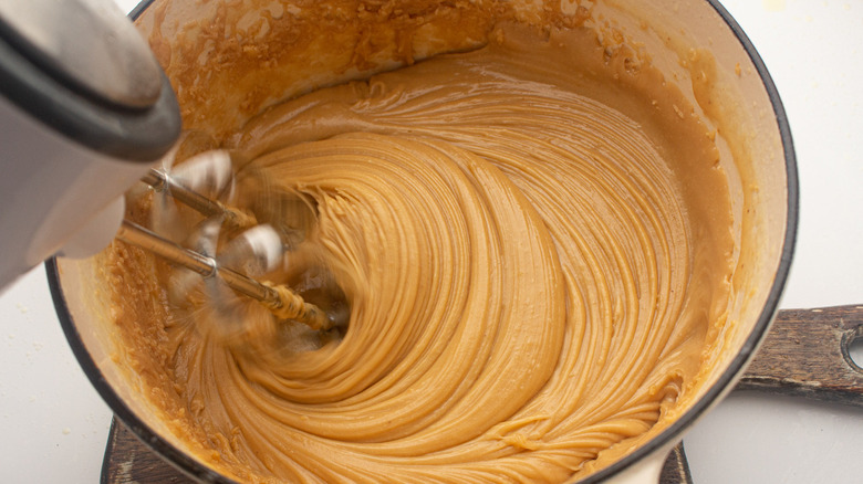 whisking fudge in saucepan