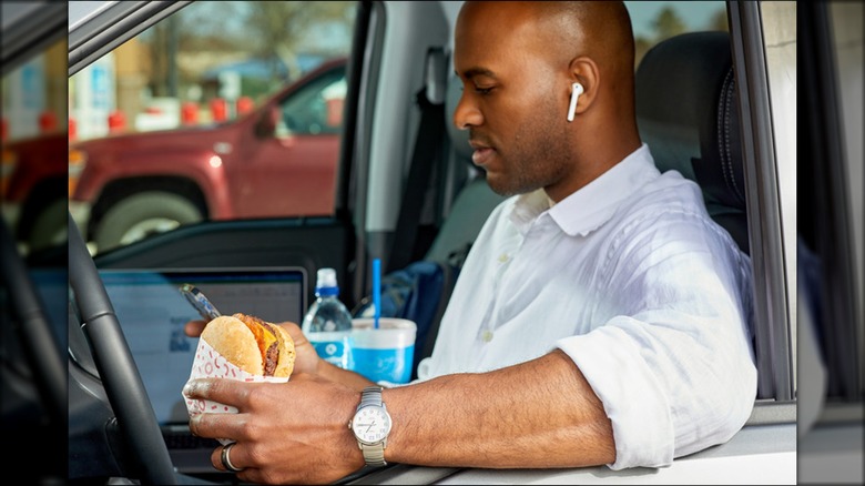 driver holding Circle K burger