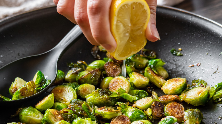 squeezing lemon on Brussels sprouts