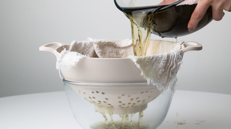 straining elderflower-infused liquid