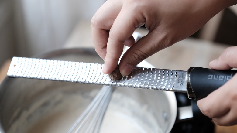 grating nutmeg in sauce